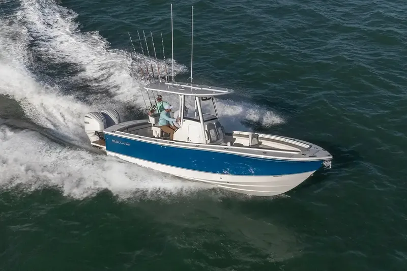 Slide: The Image of 2027 Regulator 25 boat cruising on open water with two passengers. - 7