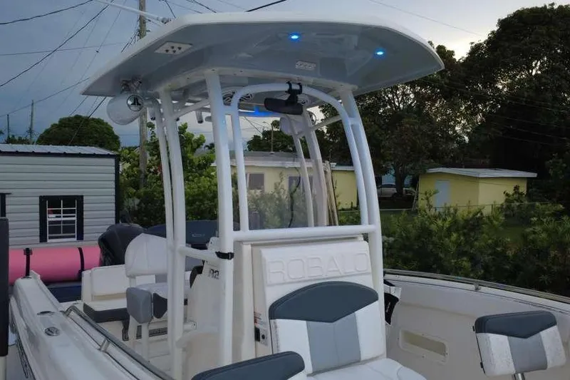 Slide: The Image of 2020 Robalo R222 Explorer boat with T-top and seating, parked outdoors. - 12
