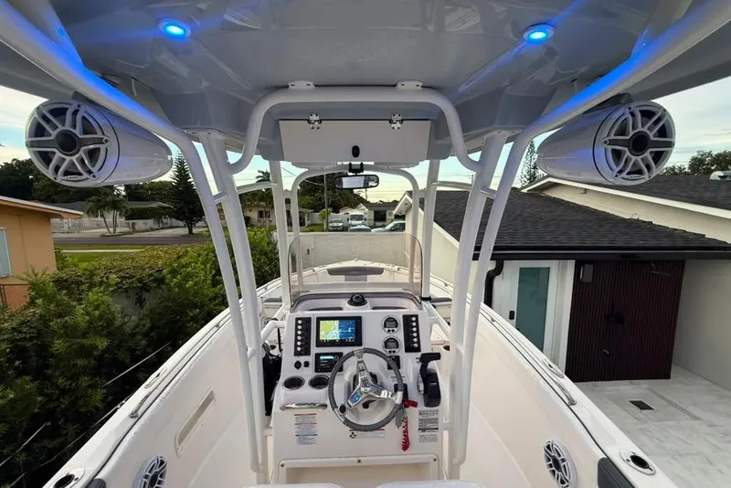 Slide: The Image of 2020 Robalo R222 Explorer boat cockpit with modern controls and speakers, docked near residential area. - 16