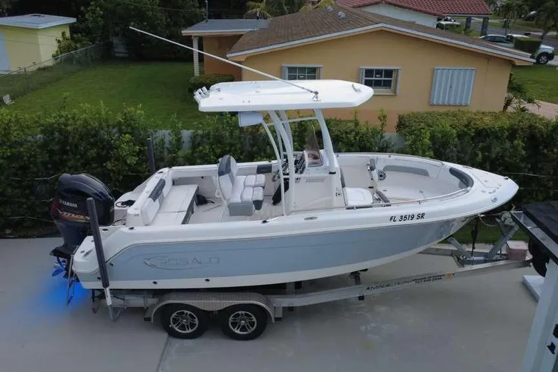 Slide: The Image of 2020 Robalo R222 Explorer boat on trailer, parked in residential driveway. - 2