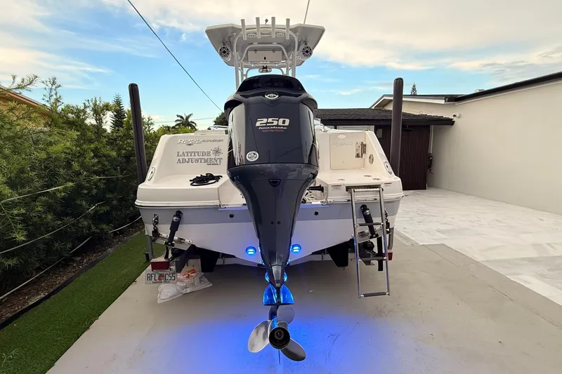Slide: The Image of 2020 Robalo R222 Explorer boat with powerful 250 engine, parked in driveway. - 25