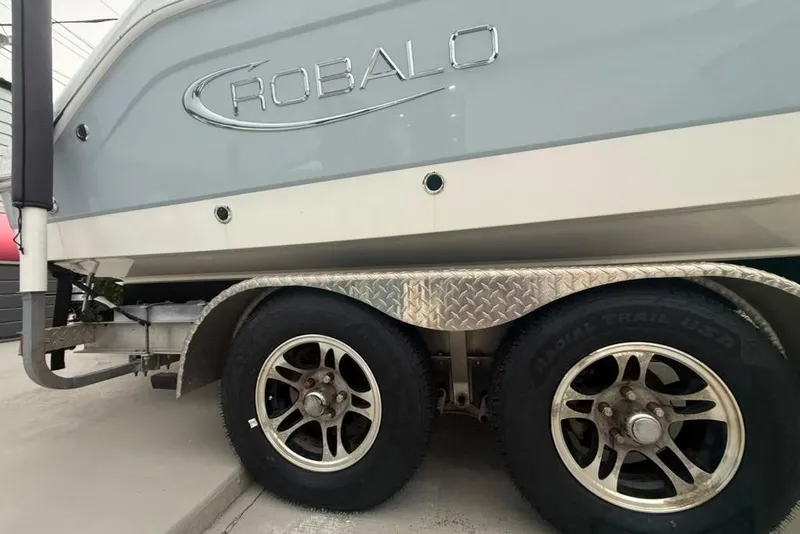 Slide: The Image of 2020 Robalo R222 Explorer boat on trailer, showcasing dual wheels and sleek design. - 27