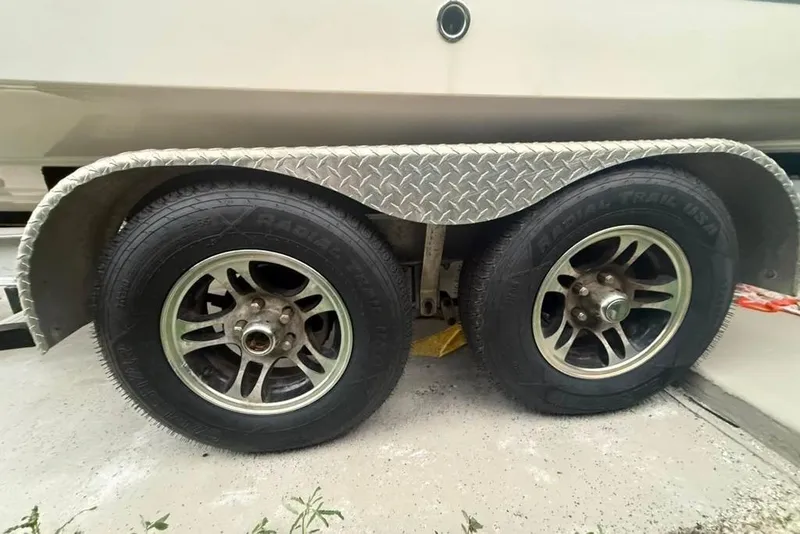 Slide: The Image of Trailer wheels of a 2020 Robalo R222 Explorer boat on concrete surface. - 28