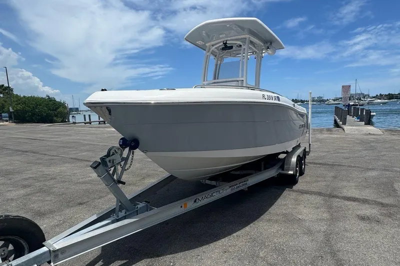 Slide: The Image of 2021 Robalo R222 Center Console boat on trailer at marina under blue sky. - 31