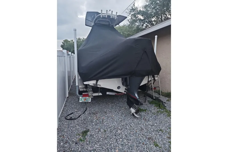 Slide: The Image of 2021 Robalo R222 Center Console boat covered, parked on gravel beside a building. - 34