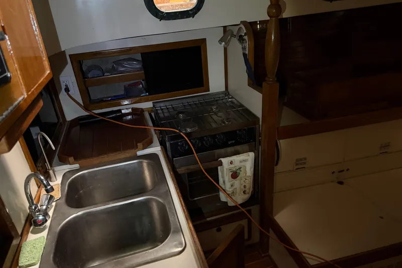 Slide: The Image of 1978 CSY 44 Center Cockpit interior with kitchen sink, stove, and storage shelves. - 17
