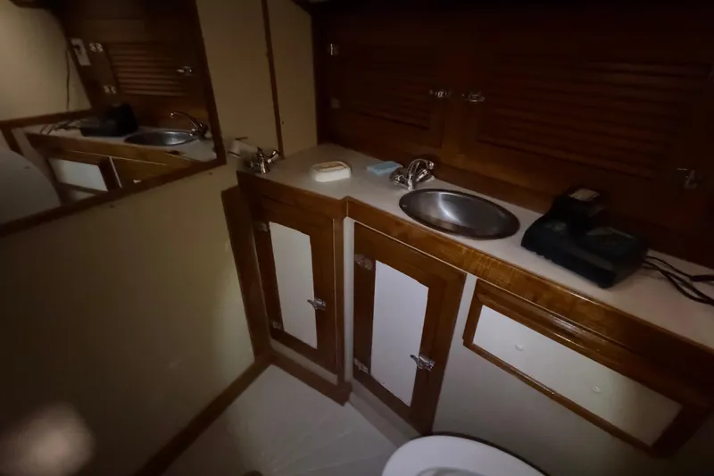 Slide: The Image of 1978 CSY 44 Center Cockpit bathroom with wooden cabinets and stainless steel sink. - 22