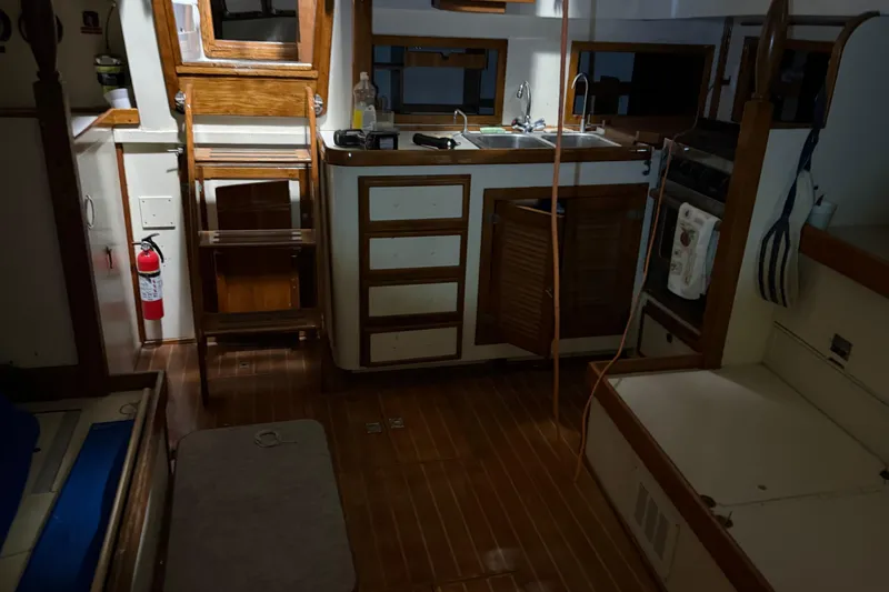 Slide: The Image of Interior of 1978 CSY 44 Center Cockpit sailboat with wooden cabinetry and kitchen area. - 23