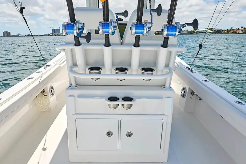 Slide: The Image of 2027 Regulator 23 boat with fishing rod holders on deck, ocean view in background. - 11