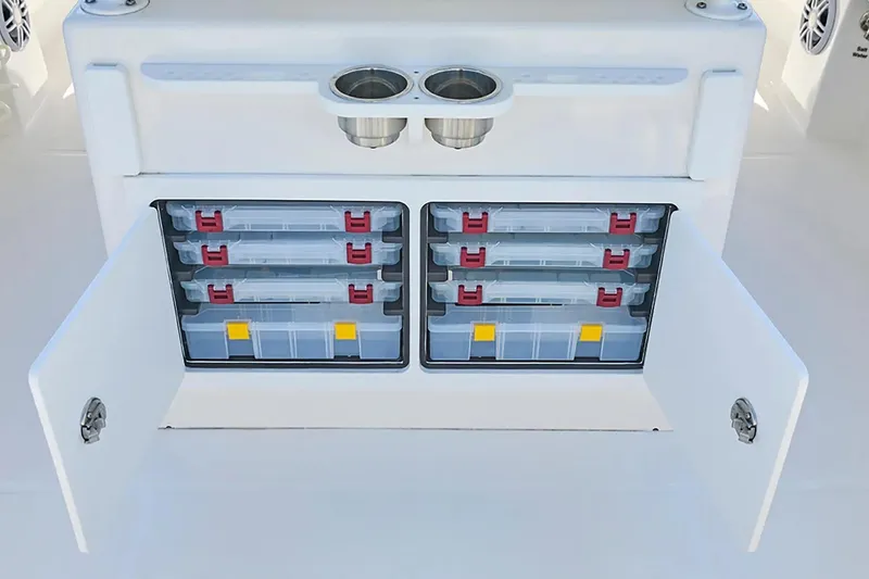 Slide: The Image of 2027 Regulator 23 boat storage compartment with organized tackle boxes and cup holders. - 12