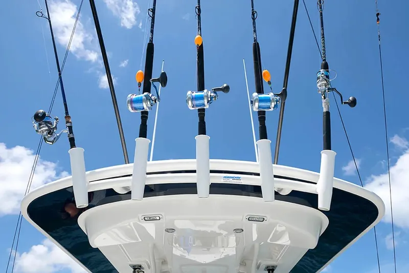 Slide: The Image of Fishing rods on a 2027 Regulator 23 boat against a clear blue sky. - 13