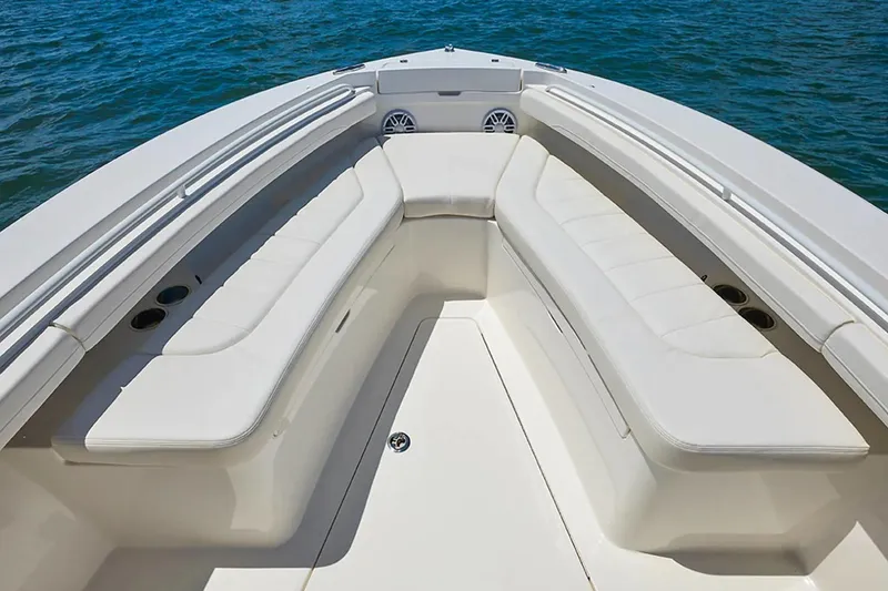 Slide: The Image of 2027 Regulator 23 boat interior with white cushioned seating and ocean backdrop. - 14
