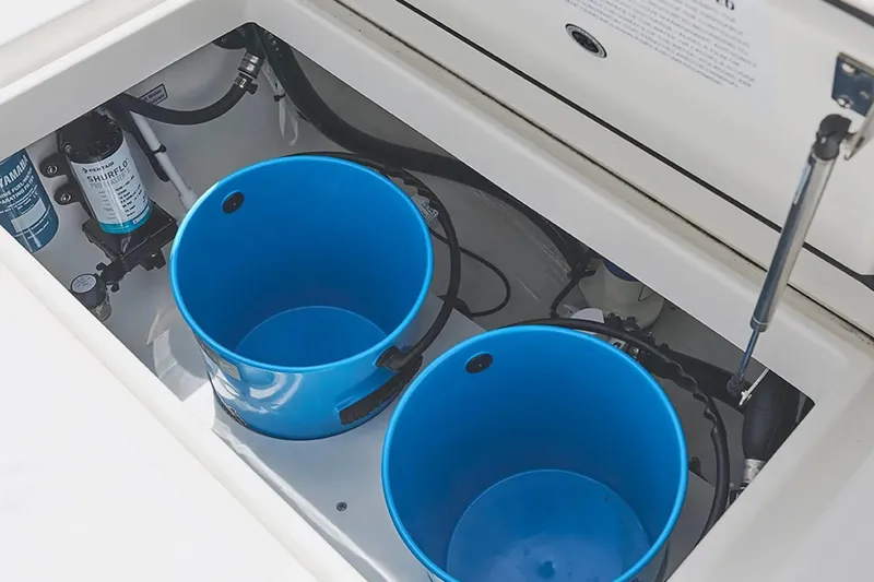 Slide: The Image of Storage compartment with blue buckets in a 2027 Regulator 23 boat. - 5
