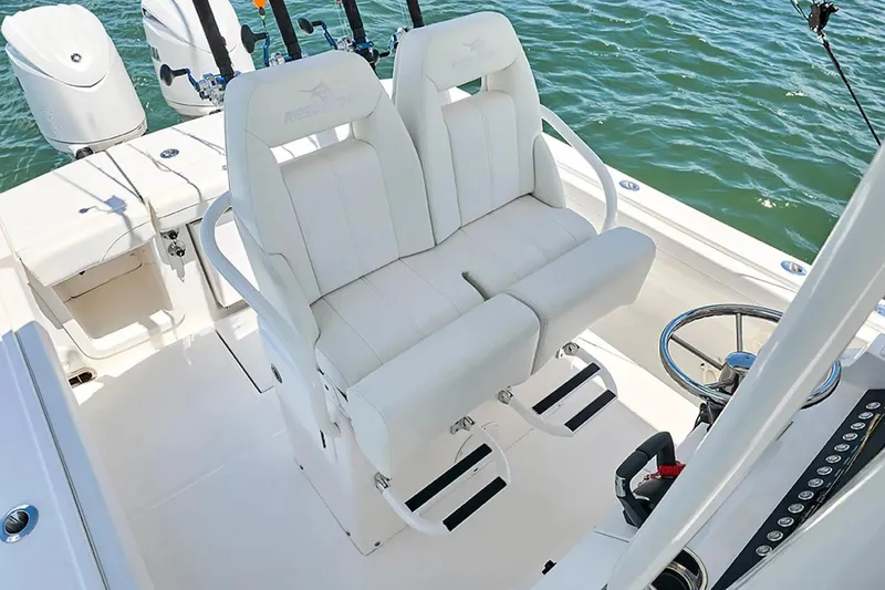 Slide: The Image of 2027 Regulator 23 boat interior with dual white captain's chairs and steering wheel. - 6