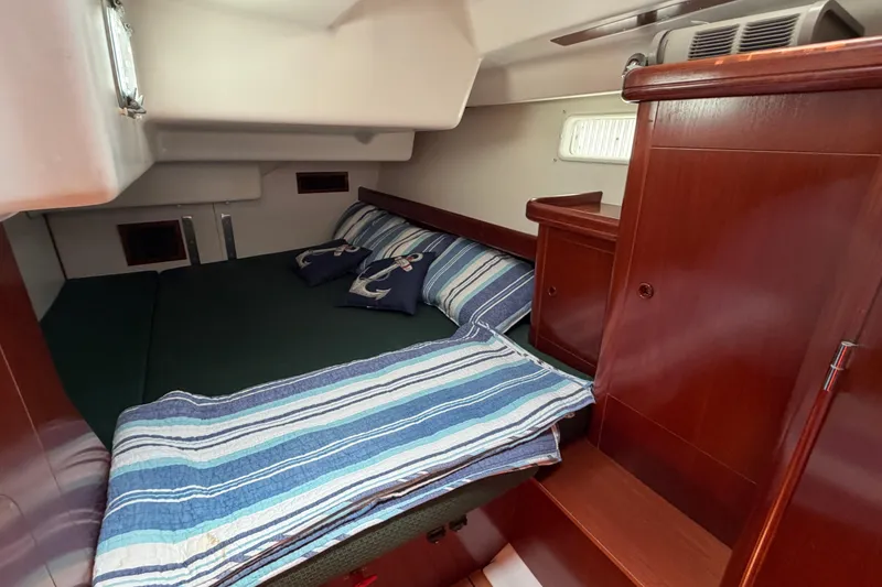Slide: The Image of Cozy cabin interior of 2003 Beneteau Oceanis 473 sailboat with striped bedding. - 12
