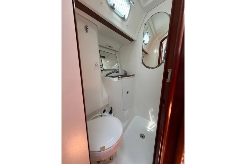 Slide: The Image of Bathroom interior of 2003 Beneteau Oceanis 473 yacht, featuring toilet and mirror. - 13