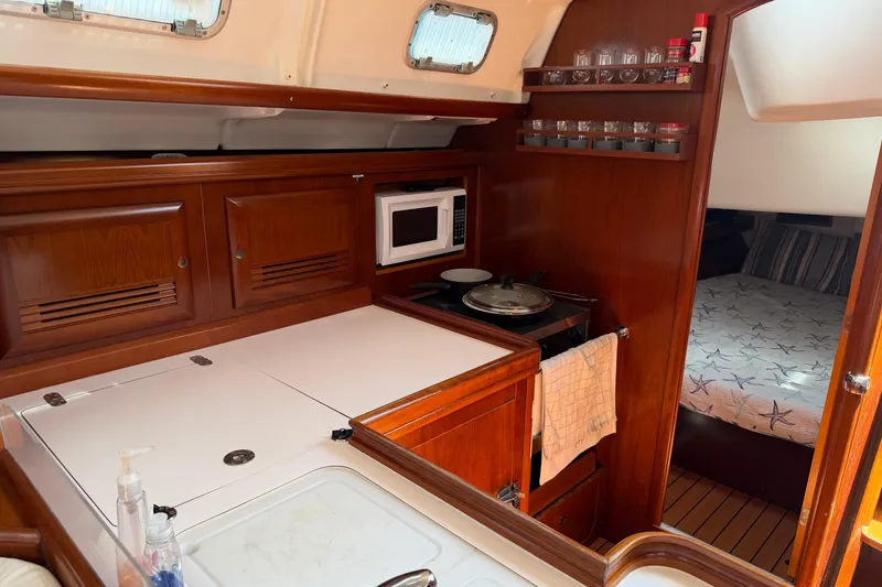 Slide: The Image of Cozy kitchen in 2003 Beneteau Oceanis 473 yacht with wooden cabinetry and modern amenities. - 14