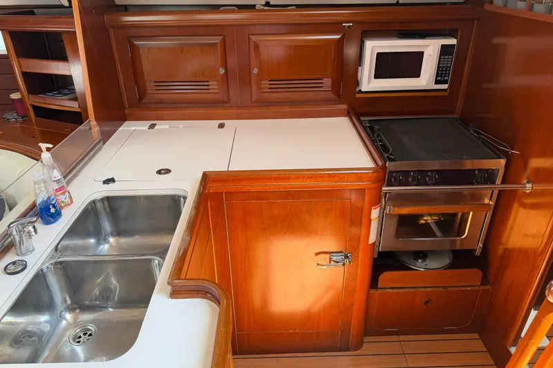 Slide: The Image of Galley kitchen in 2003 Beneteau Oceanis 473 yacht with sink, stove, and microwave. - 15