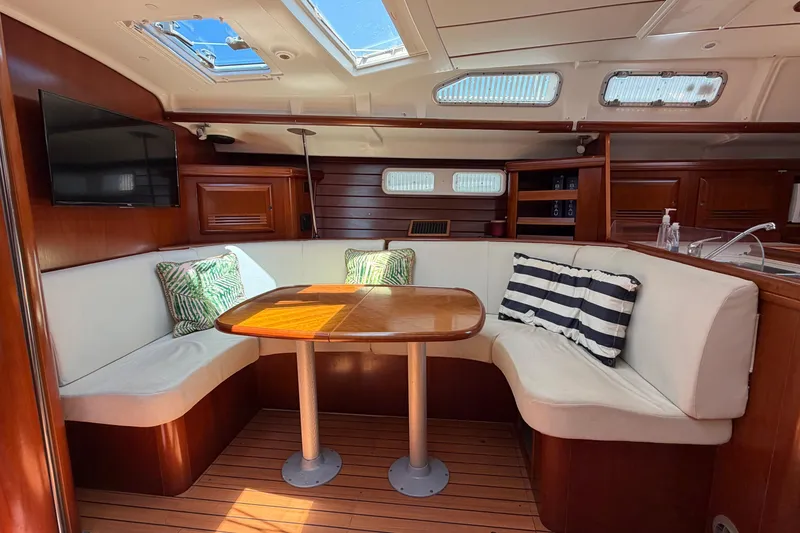 Slide: The Image of Interior of 2003 Beneteau Oceanis 473 yacht with cozy seating and wooden table. - 16