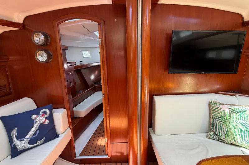 Slide: The Image of Interior of 2003 Beneteau Oceanis 473 yacht with wood paneling and cozy seating area. - 17