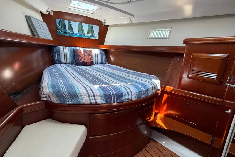 Slide: The Image of Cozy cabin interior of 2003 Beneteau Oceanis 473 sailboat with striped bedding and nautical decor. - 18