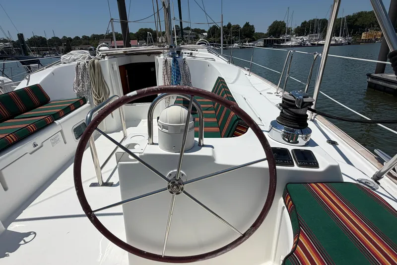 Slide: The Image of Cockpit of 2003 Beneteau Oceanis 473 sailboat with striped cushions and steering wheel. - 23
