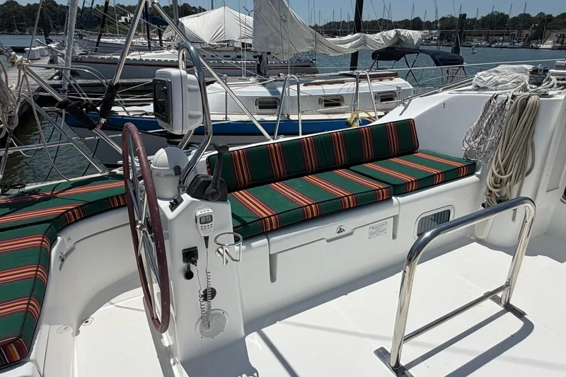 Slide: The Image of Cockpit of 2003 Beneteau Oceanis 473 sailboat with striped cushions and steering wheel. - 24
