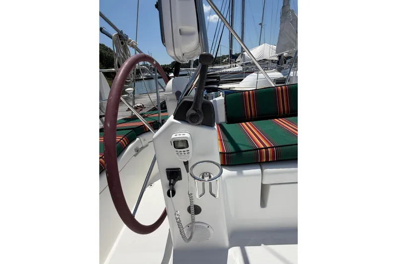 Slide: The Image of Cockpit of 2003 Beneteau Oceanis 473 sailboat with striped cushions and steering wheel. - 25