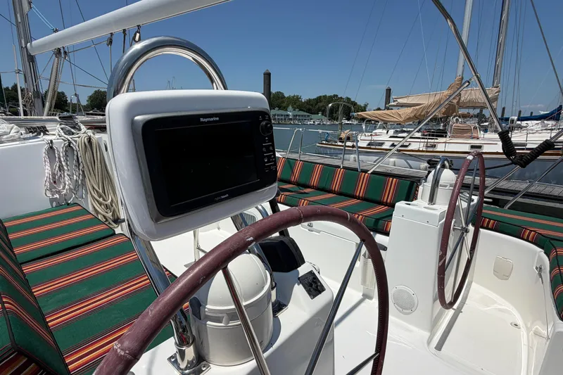 Slide: The Image of Cockpit of 2003 Beneteau Oceanis 473 sailboat with striped seating and navigation equipment. - 26