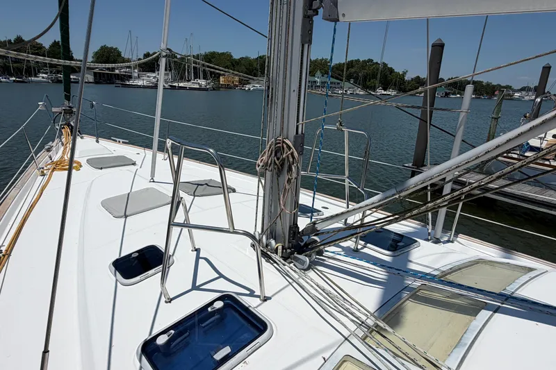 Slide: The Image of 2003 Beneteau Oceanis 473 sailboat deck with rigging, docked in a serene marina. - 29