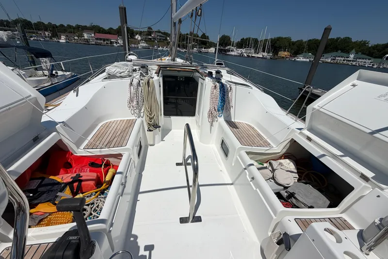 Slide: The Image of 2003 Beneteau Oceanis 473 sailboat cockpit with open storage compartments, docked at marina. - 3