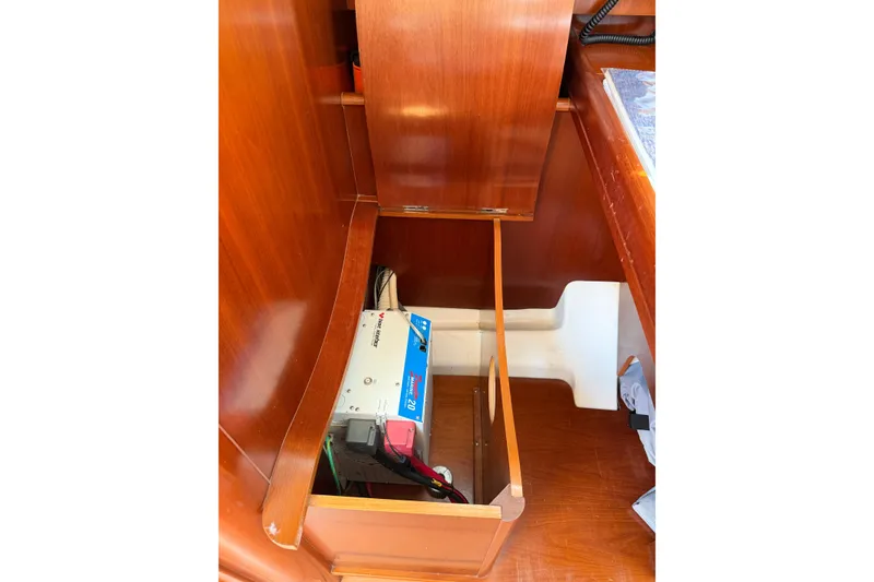 Slide: The Image of 2003 Beneteau Oceanis 473 interior showing electrical components in wooden compartment. - 9