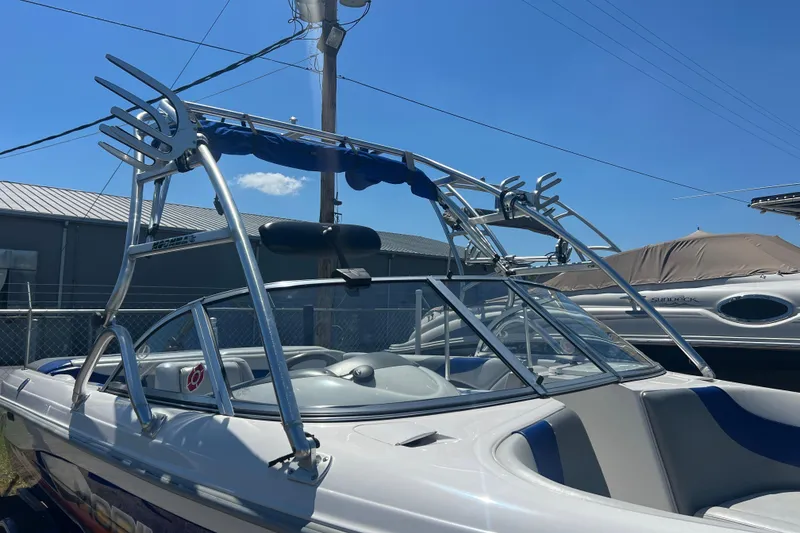 Slide: The Image of 2002 Moomba Mobius LSV boat with wakeboard tower under clear blue sky. - 16