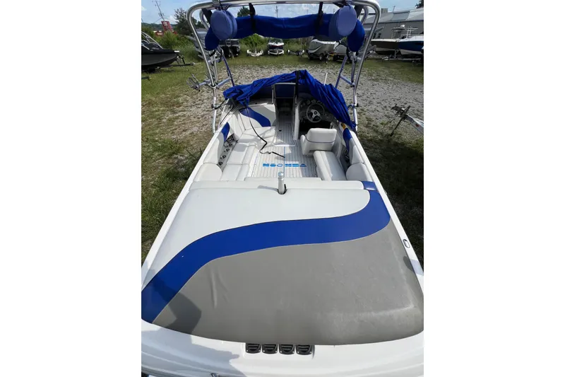 Slide: The Image of 2002 Moomba Mobius LSV boat with blue and gray interior, parked on grass. - 6