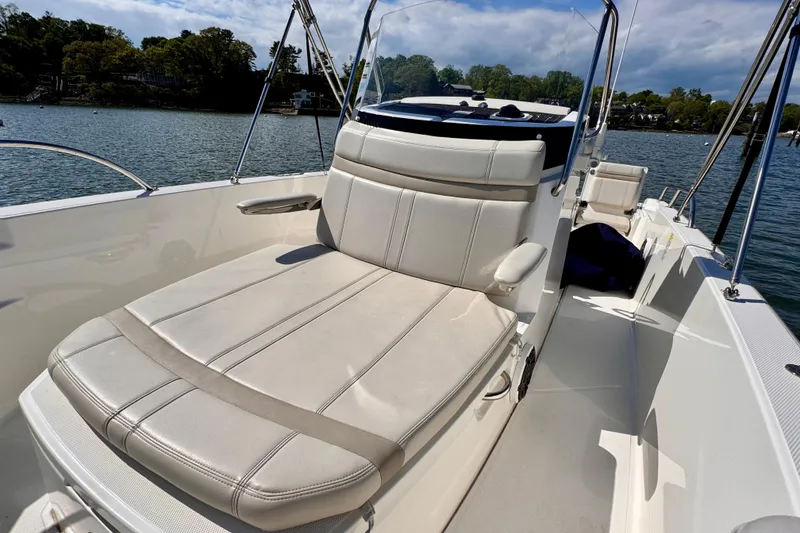 Slide: The Image of 2022 Boston Whaler 220 Dauntless boat interior with comfortable seating on a sunny day. - 6