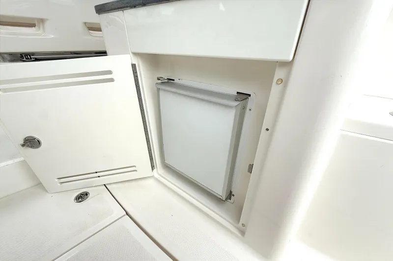 Slide: The Image of 2013 Sea Ray Sundancer 350 interior storage compartment with open door. - 9