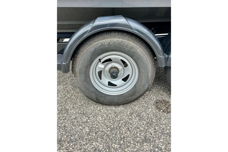 Slide: The Image of Trailer wheel of a 2015 Yamaha Boats AR210 on asphalt surface. - 14