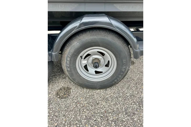 Slide: The Image of Trailer wheel of a 2015 Yamaha Boats AR210 on asphalt surface. - 15