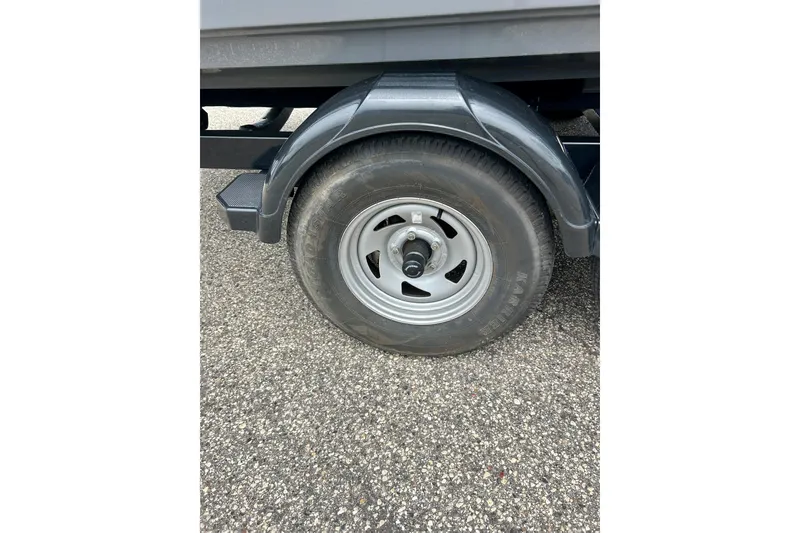 Slide: The Image of Trailer wheel of a 2015 Yamaha Boats AR210 on asphalt surface. - 16