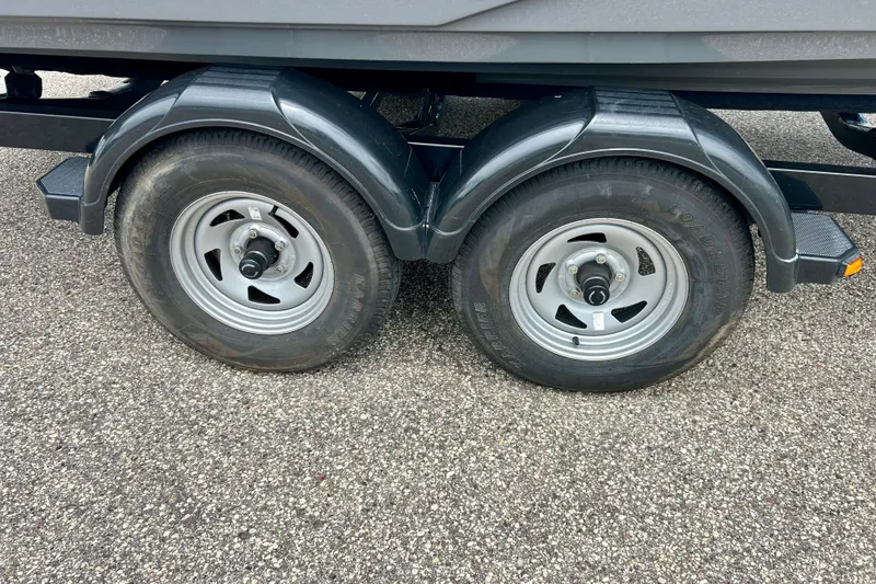Slide: The Image of Trailer wheels of a 2015 Yamaha Boats AR210 on asphalt surface. - 18