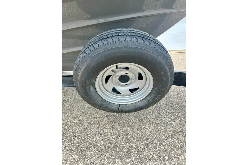 Slide: The Image of Trailer tire for 2015 Yamaha Boats AR210 on pavement. - 19
