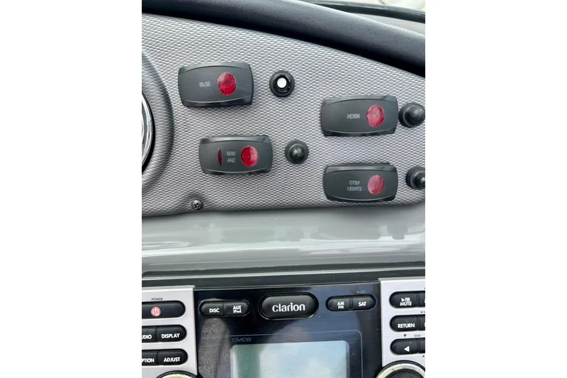 Slide: The Image of Control panel of a 2015 Yamaha Boats AR210 with switches and Clarion audio system. - 29