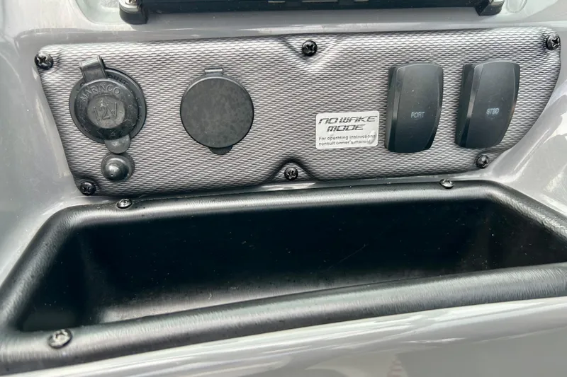 Slide: The Image of Control panel of a 2015 Yamaha Boats AR210, featuring switches and a 12V outlet. - 32