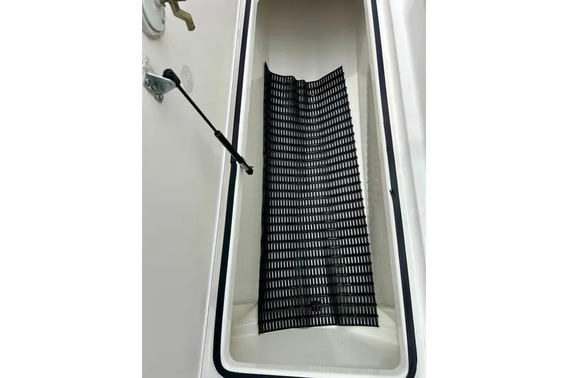 Slide: The Image of Storage compartment of a 2015 Yamaha AR210 boat with a black mat inside. - 47