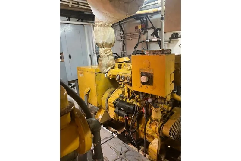 Slide: The Image of Engine room of a 1995 Custom Steel Albacore Tuna Vessel, featuring yellow machinery and pipes. - 20