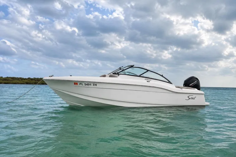 The Image of 2023 Scout 210 Dorado boat on calm turquoise water under cloudy sky. - 1