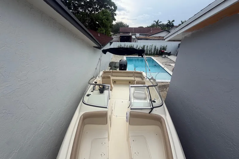 Slide: The Image of 2023 Scout 210 Dorado boat parked beside a pool in a residential backyard. - 11