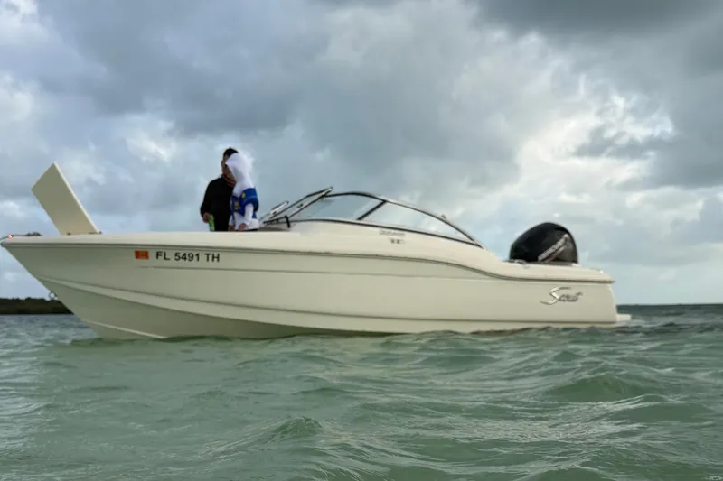 Slide: The Image of 2023 Scout 210 Dorado boat on water under cloudy sky. - 3