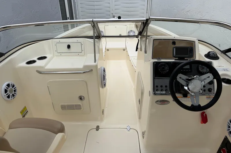 Slide: The Image of 2023 Scout 210 Dorado boat interior with steering wheel and dashboard controls. - 4