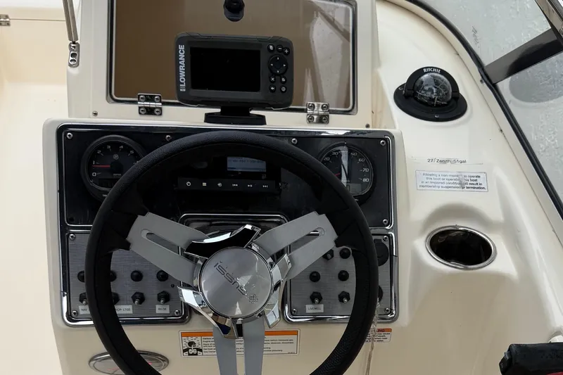 Slide: The Image of 2023 Scout 210 Dorado boat dashboard with steering wheel and navigation equipment. - 5
